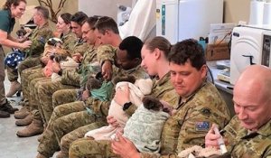 Au moment de leur pause, des soldats nourrissent des koalas dans un parc en Australie