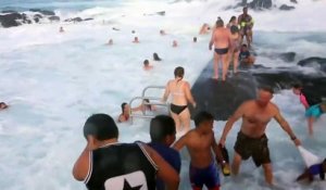 Des touristes surpris par une grosse vague dans une piscine naturelle