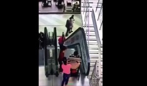 Cette fillette veut de descendre un escalator avec la poussette de son petit frère... mauvaise idée