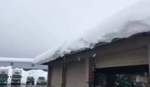 Déneiger le toit d'un entrepôt rempli de neige