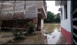 Un immeuble bascule d'un coup dans le fleuve pendant une inondation