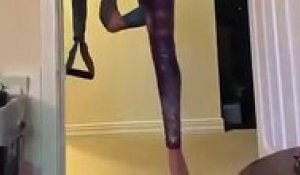 Une jeune gymnaste parvient à se tenir en équilibre sur des élastiques fixés à sa porte