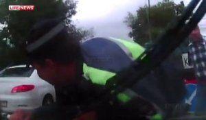 Un policier russe accroché sur un capot de voiture