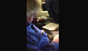 Un homme endormi sur son ordinateur dans un avion