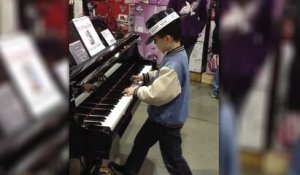 Un jeune garçon joue du piano comme personne dans un magasin