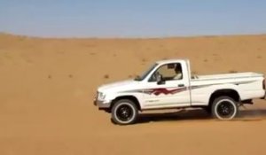 Un super pick-up grimpe une dune de sable
