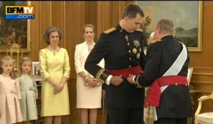 Juan Carlos remet l'écharpe qui incarne l'autorité militaire à son fils, Felipe VI - 19/06