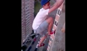 Un Ukrainien se pend d'une main du haut d'un immeuble