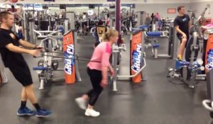 Une femme tire un homme en salle de gym! Vision surréaliste!