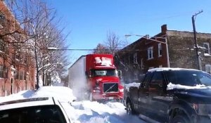 Un pick-up remorque un camion bloqué dans la neige