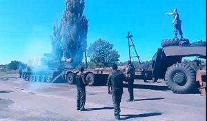 Un soldat Ukrainien essaye de charger un char sur un camion
