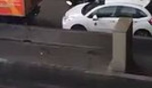 un chauffeur de taxi jette un pavé sur une voiture