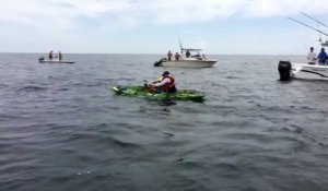 Un requin retourne le kayak d'un pecheur qui tente de le remonter