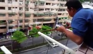 Un homme pêche un poisson depuis son balcon