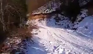 Un homme en camionnette s'amuse à glisser sur une route enneigée