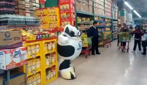 Une mascotte vache danse dans un supermarché