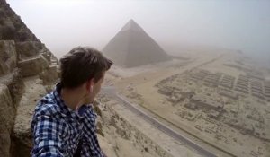 Un jeune homme grimpe au sommet de la Pyramide de Khéops