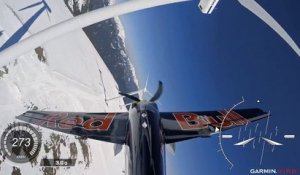 Un avion de voltige slalome dans un champ d'éoliennes