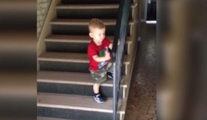 Un enfant très prudent se rate en descendant des escaliers
