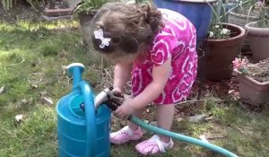 Cette petite fille s'amuse avec un tuyau d'arrosage