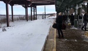 Un train entre dans une gare complètement enneigée !