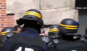 Un CRS frappe avec sa matraque les manifestants qui ne lèvent pas les bras