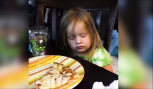 Cette fillette hésite entre dormir ou manger sa pizza...