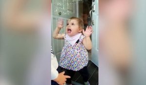 Cette petite fille adore faire des grimaces à travers la vitre !