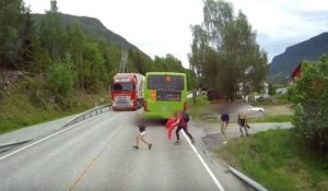 Un écolier traverse une route derrière un bus