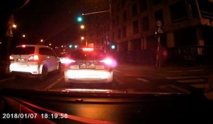 Griller un feu rouge à côté d'une voiture de police