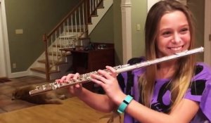 Son chien chante pendant qu'elle joue de la flûte