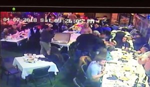 Un homme saute sur une table pour aider son pote pendant une bagarre dans un restaurant