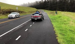 Accroché sur le toit d'une voiture pendant des donuts