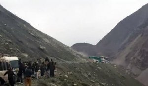 Un bus bloqué sous une pluie de rochers sur une route de montagne