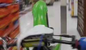 Un homme lève sa moto dans un supermarché