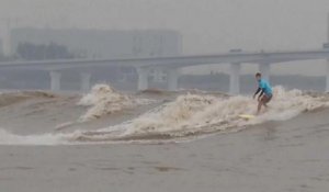Des surfeurs tentent de dompter la vague géante du fleuve Qiantang en Chine