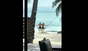 Ce couple fait de la balançoire sur une plage paradisiaque... Enfin presque