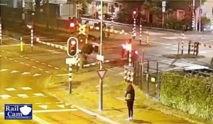 Un homme en scooter regarde une fille dans la rue et se prend la barrière du passage à niveau