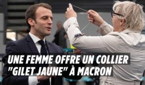 Une femme offre à Emmanuel Macron un collier en forme de gilet jaune
