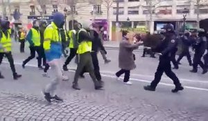 Un CRS se prend un coup de pied dans la tête par un gilet jaune sur les Champs-Elysées