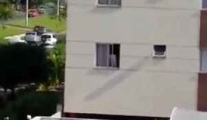 Un bébé joue sur le rebord de la fenêtre au 4ème étage