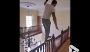 Sport extrême à la maison il marche en équilibre sur la rampe d'escalier