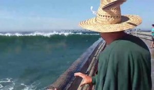 Des touristes sur un ponton de font surprendre par une grosse vague