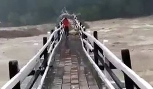 Ils traversent un pont piéton lors d'une crue