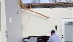 Un homme joue du piano dans une maison détruite par une tornade