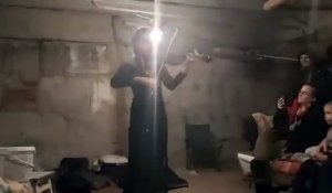 Une violoniste joue du violon dans les sous sols de bunker en Ukraine