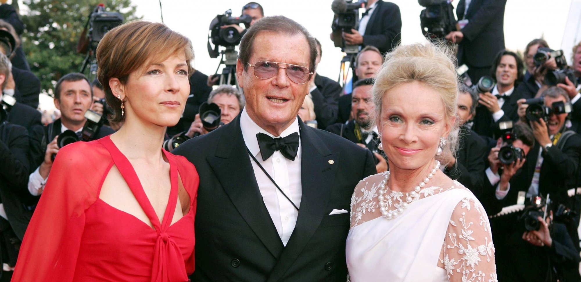 Roger Moore entouré de Deborah Moore et Christina Tholstrup au Festival de Cannes 2004.