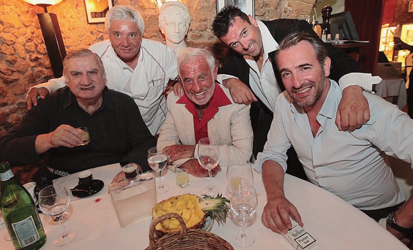 Mamo, le propriétaire du restaurant Le Michelangelo entouré d'Aldo Maccione, Jean-Paul Belmondo et Jean Dujardin, à Antibes, le 19 décembre 2012.