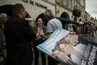La candidate RN aux législatives, Sandrine Chadourne (c), distribue des tracts sur un marché à Libourne, le 2 juillet 2024 en Gironde