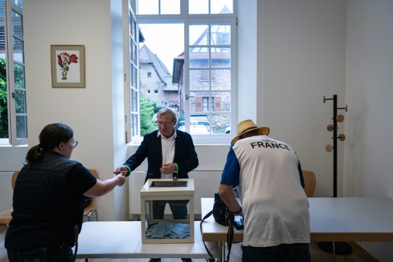Une femme regarde les affiches électorales des candidats aux législatives à Wissembourg, le 30 juin 2024 dans le Bas-Rhin